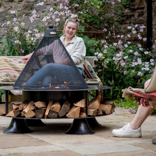 Flat Ring of Logs 120 Lit on patio with Mesh Guard and people - Lifestyle - Firepits UK - LoRes600x600 481