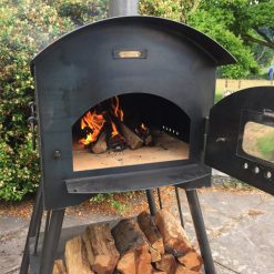 Taditional Pizza Oven Fire Pit Lit with Logs and Open Door Lifestyle - Firepits UK - WEB - Lo Res 600x600