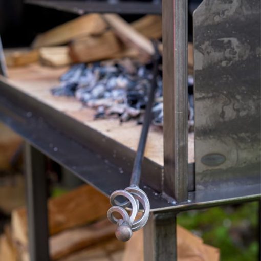 Wrought Iron Fire Poker resting on Asado