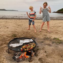 Beach BBQ Fire Pit Lit with Veg facing Sea Lifestyle - Firepits UK - WEB - Lo Res