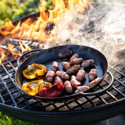 Wine Glass Fire Pit Lit with Half Moon BBQ Rack and Skillet Pan with Peppers and Pigs in Blankets Close Up Lifestyle - Firepits UK - WEB - Lo Res