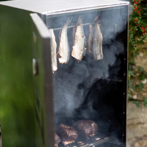 Herring smoking in Hot Smoker Cabinet preparing food for outdoor firepit
